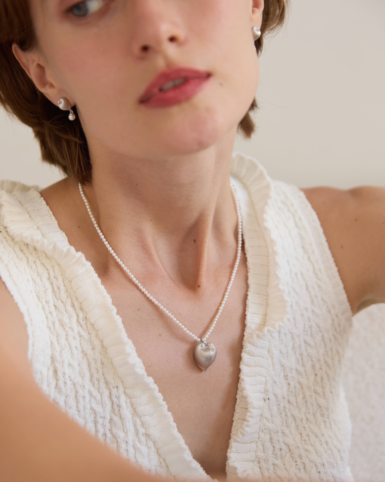 Woman wearing a necklace with a heart pendant, with 'Celestes Jewelry' branding.