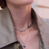 Close-up of a person wearing a necklace with 'Célestes Jewelry' branding.