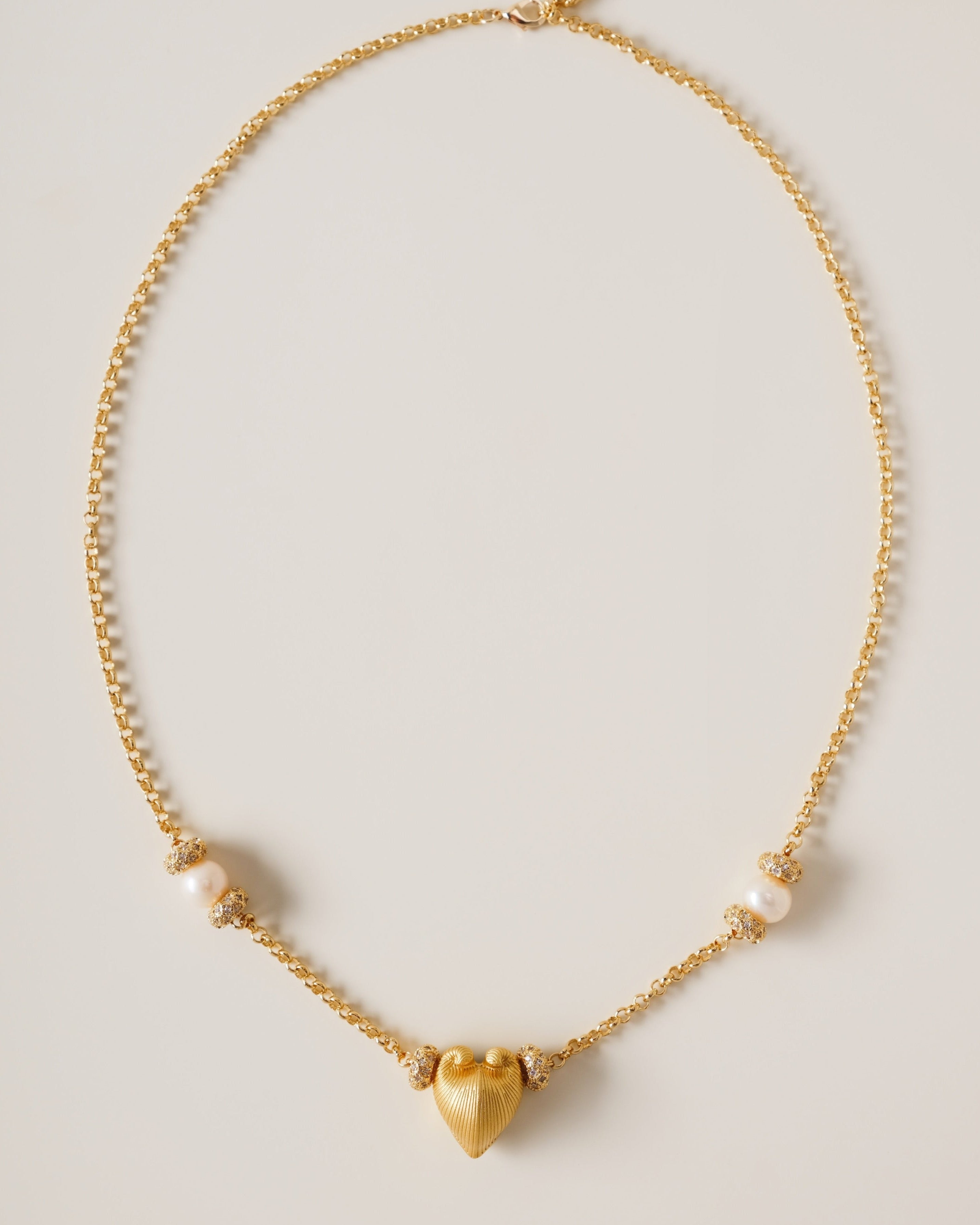 A celestial symphony of love and light, the Meiocardia Vulgaris Heart Necklace is a masterful blend of organic allure and cosmic opulence. Designed for those who seek to wear the stars and the sea, this piece balances bold symbolism with delicate harmony, celebrating the interplay of strength and softness.
Design & Craftsmanship:
Striking Heart Pendant: The centerpiece is a 15.6*18.8mm Meiocardia vulgaris heart bead, cast in lustrous S925 silver and plated with 18k gold. Its dual-textured surface—rugged edg