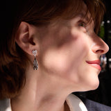 Close-up of a woman wearing silver earrings with a blurred background