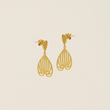 Gold earrings on a beige background