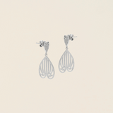 Celestes jewelry Pair of silver earrings on a beige background