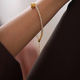 Pearl bracelet on a wrist with a blurred background, featuring the brand 'Celestes Jewelry'.