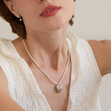 Woman wearing a necklace with a heart pendant, with 'Celestes Jewelry' branding.