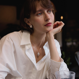 Woman in a white shirt holding a glass with a blurred background