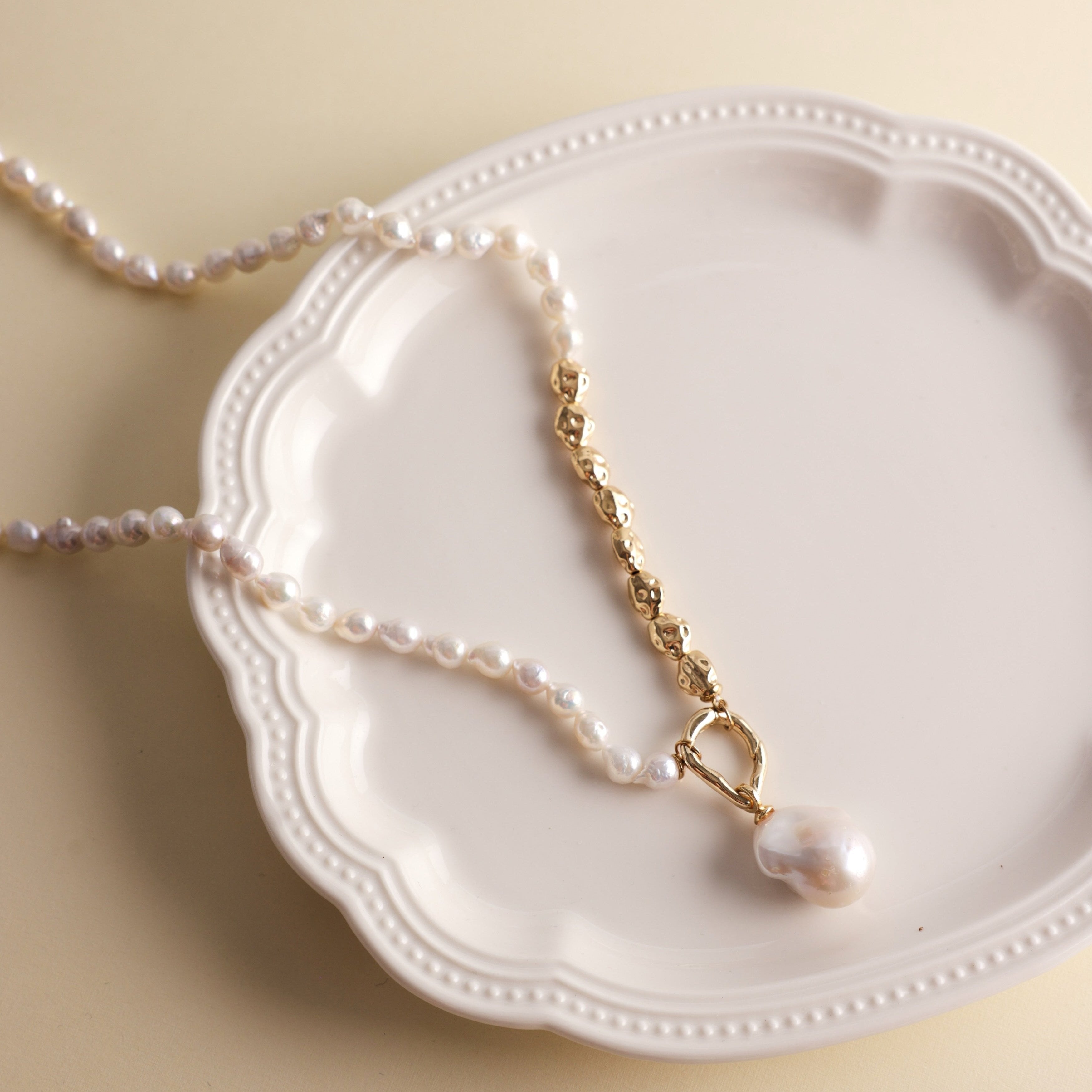 Embrace the beauty of asymmetry with this stunning Baroque freshwater pearl necklace. Featuring a lustrous Baroque pearl pendant, this piece stands out with its natural glow and unique shape. The pendant is detachable, allowing you to add it to other necklaces for a customized look. The chain and accents are crafted from 18k gold-filled materials, ensuring long-lasting color and a beautiful shine that complements the pearls.