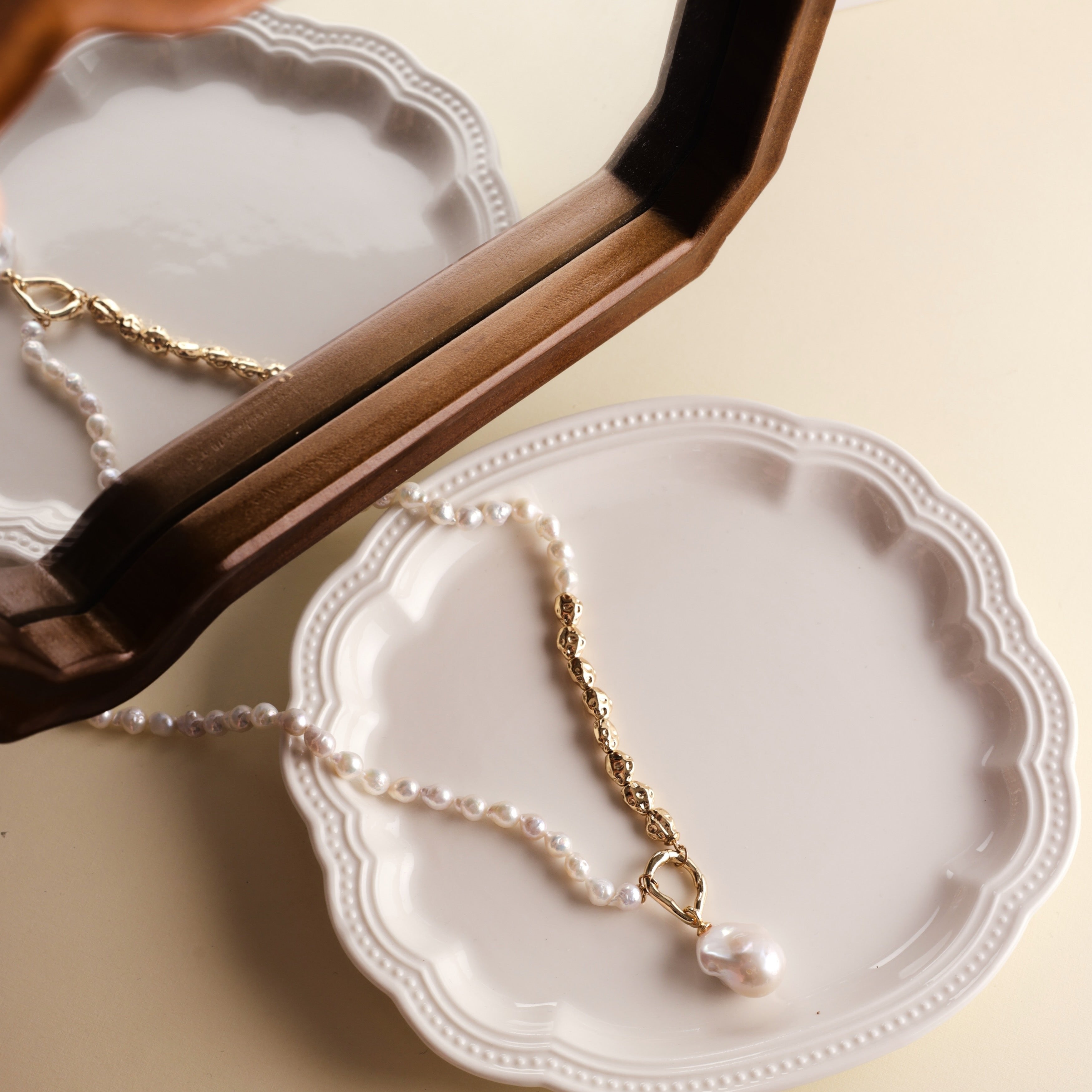 Embrace the beauty of asymmetry with this stunning Baroque freshwater pearl necklace. Featuring a lustrous Baroque pearl pendant, this piece stands out with its natural glow and unique shape. The pendant is detachable, allowing you to add it to other necklaces for a customized look. The chain and accents are crafted from 18k gold-filled materials, ensuring long-lasting color and a beautiful shine that complements the pearls.