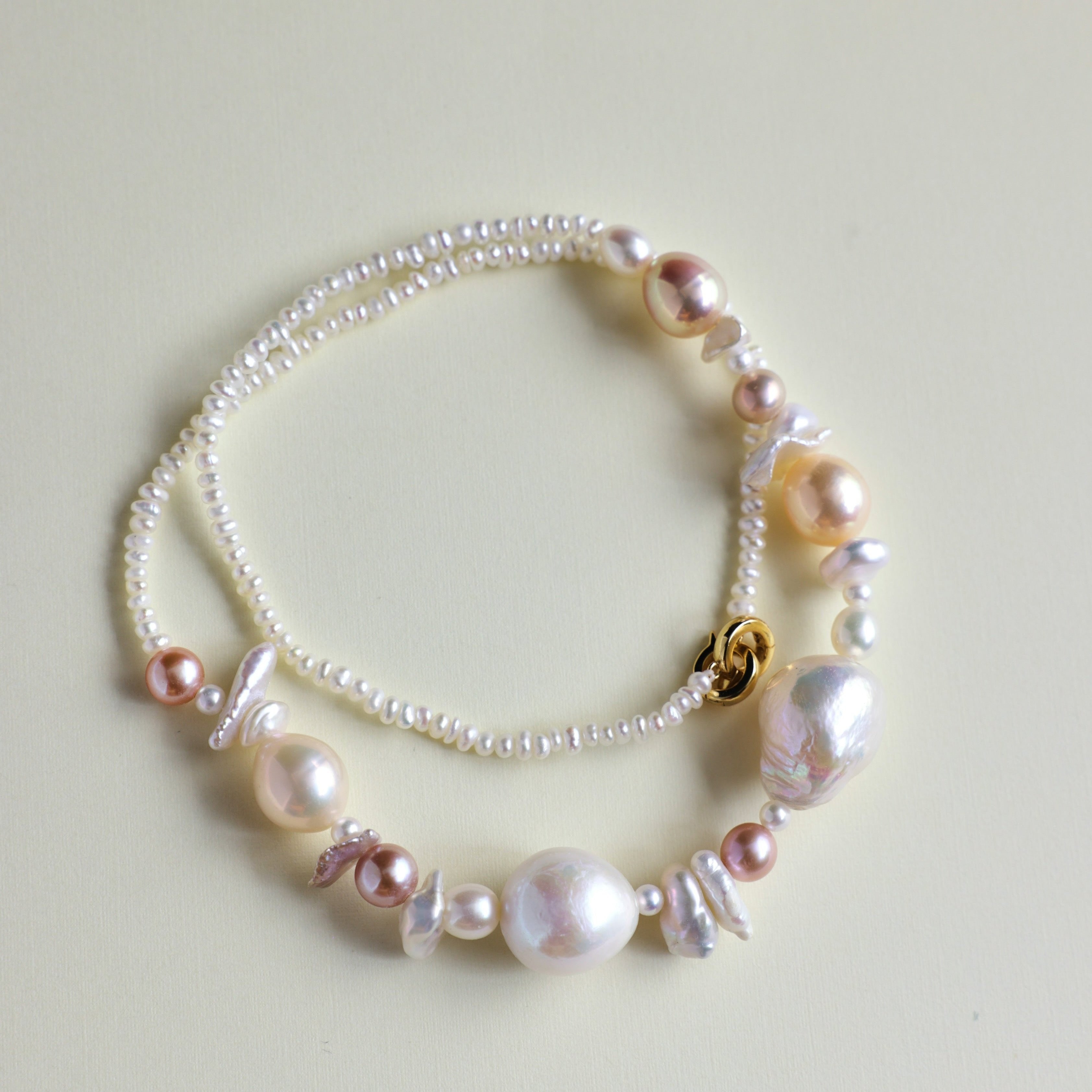 The seaside treasure pearl necklace can be customized to match your favorite color palette! Featuring a stunning mix of pink-hued freshwater pearls—Baroque pearls, Keshi pearls, round pearls, and tiny seed pearls—this necklace is a one-of-a-kind piece. Each strand is handmade with love and care, ensuring that your necklace is truly special and as unique as you are.

The Meaning Behind Pink Pearls & Baroque Pearls