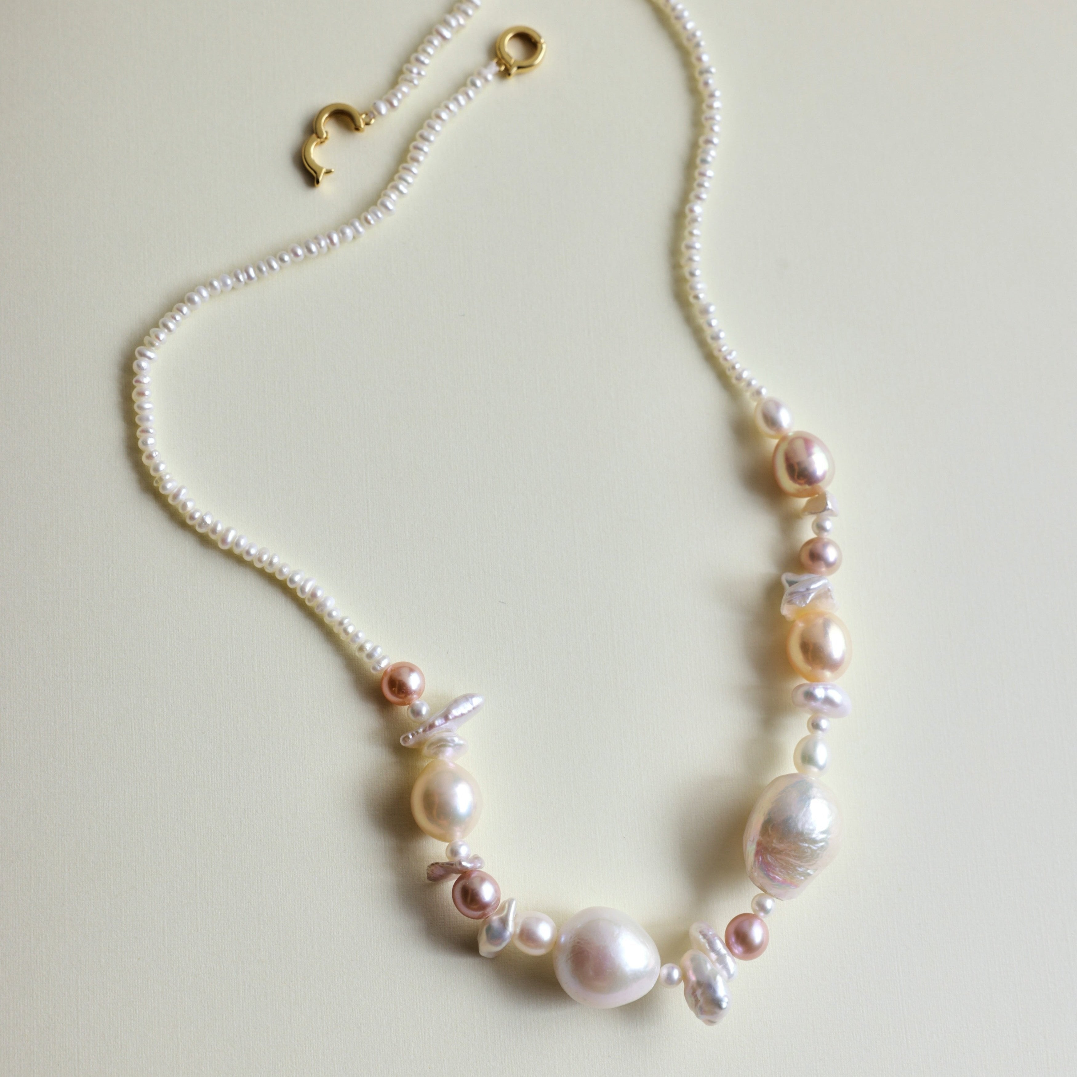 The seaside treasure pearl necklace can be customized to match your favorite color palette! Featuring a stunning mix of pink-hued freshwater pearls—Baroque pearls, Keshi pearls, round pearls, and tiny seed pearls—this necklace is a one-of-a-kind piece. Each strand is handmade with love and care, ensuring that your necklace is truly special and as unique as you are.

The Meaning Behind Pink Pearls & Baroque Pearls