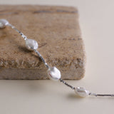 Materials:
- Pearls: Five lustrous Keshi pearls, each about 10mm long.
- Metal: High-quality 925 Sterling Silver for all hardware and detailing.
- Length: The bracelet measures 18.5 cm, featuring an adjustable chain for a customized fit.
Design Highlights: 
This piece is skillfully crafted, showcasing a minimalist yet striking design. The irregularity of the Keshi pearls provides a modern twist on a classic bracelet, complemented by delicate sterling silver accents that add a refined touch.
Styling Tips:
- 
