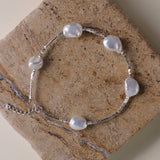 Materials:
- Pearls: Five lustrous Keshi pearls, each about 10mm long.
- Metal: High-quality 925 Sterling Silver for all hardware and detailing.
- Length: The bracelet measures 18.5 cm, featuring an adjustable chain for a customized fit.
Design Highlights: 
This piece is skillfully crafted, showcasing a minimalist yet striking design. The irregularity of the Keshi pearls provides a modern twist on a classic bracelet, complemented by delicate sterling silver accents that add a refined touch.
Styling Tips:
- 