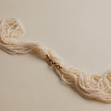 This extraordinary necklace is crafted from thousands of the world's smallest Akoya saltwater pearls, delicately hand-strung into 10 graceful strands. Each pearl measures just 1.0-1.5mm in size, a true testament to the incredible craftsmanship required to create such a piece. The process of drilling these baby pearls is so precise that nearly 1/3 of the pearls are lost, making this necklace an exceptionally rare and luxurious creation. These pearls are the type you’d expect to see in high couture jewelry, r