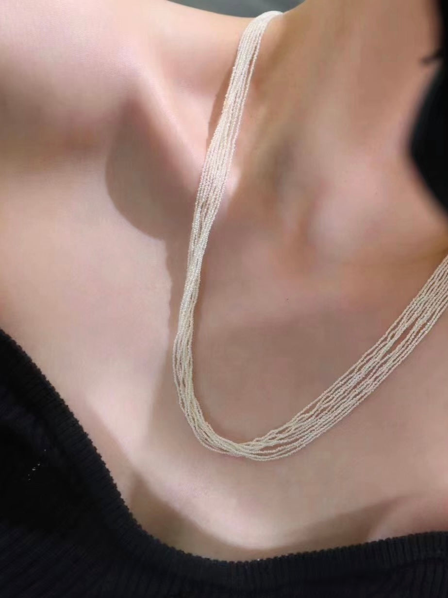 This extraordinary necklace is crafted from thousands of the world's smallest Akoya saltwater pearls, delicately hand-strung into 10 graceful strands. Each pearl measures just 1.0-1.5mm in size, a true testament to the incredible craftsmanship required to create such a piece. The process of drilling these baby pearls is so precise that nearly 1/3 of the pearls are lost, making this necklace an exceptionally rare and luxurious creation. These pearls are the type you’d expect to see in high couture jewelry, r