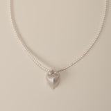 Discover the celestial union of strength and grace with our Cœur Brillant Heart & Pearl Necklace, a wearable ode to self-love and cosmic wonder. Anchored by a striking Meiocardia vulgaris-inspired heart pendant (15.6*18.8mm) crafted in 925 silver plated with radiant 18k gold, this necklace intertwines nature’s duality with timeless elegance. Paired with a lustrous strand of 3-3.5mm freshwater pearls, it’s a symphony of celestial artistry designed to illuminate every chapter of your journey.  

Design Detail