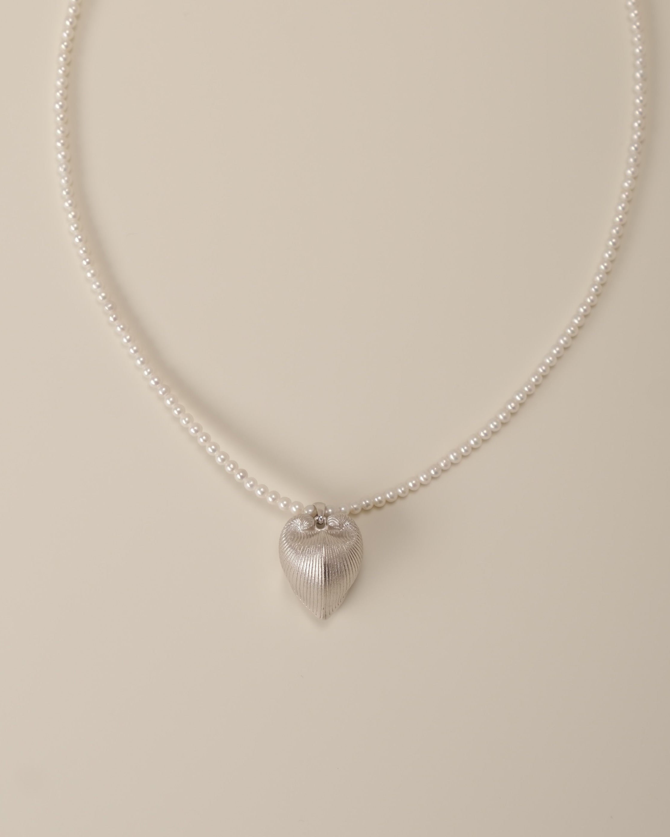 Discover the celestial union of strength and grace with our Cœur Brillant Heart & Pearl Necklace, a wearable ode to self-love and cosmic wonder. Anchored by a striking Meiocardia vulgaris-inspired heart pendant (15.6*18.8mm) crafted in 925 silver plated with radiant 18k gold, this necklace intertwines nature’s duality with timeless elegance. Paired with a lustrous strand of 3-3.5mm freshwater pearls, it’s a symphony of celestial artistry designed to illuminate every chapter of your journey.  

Design Detail