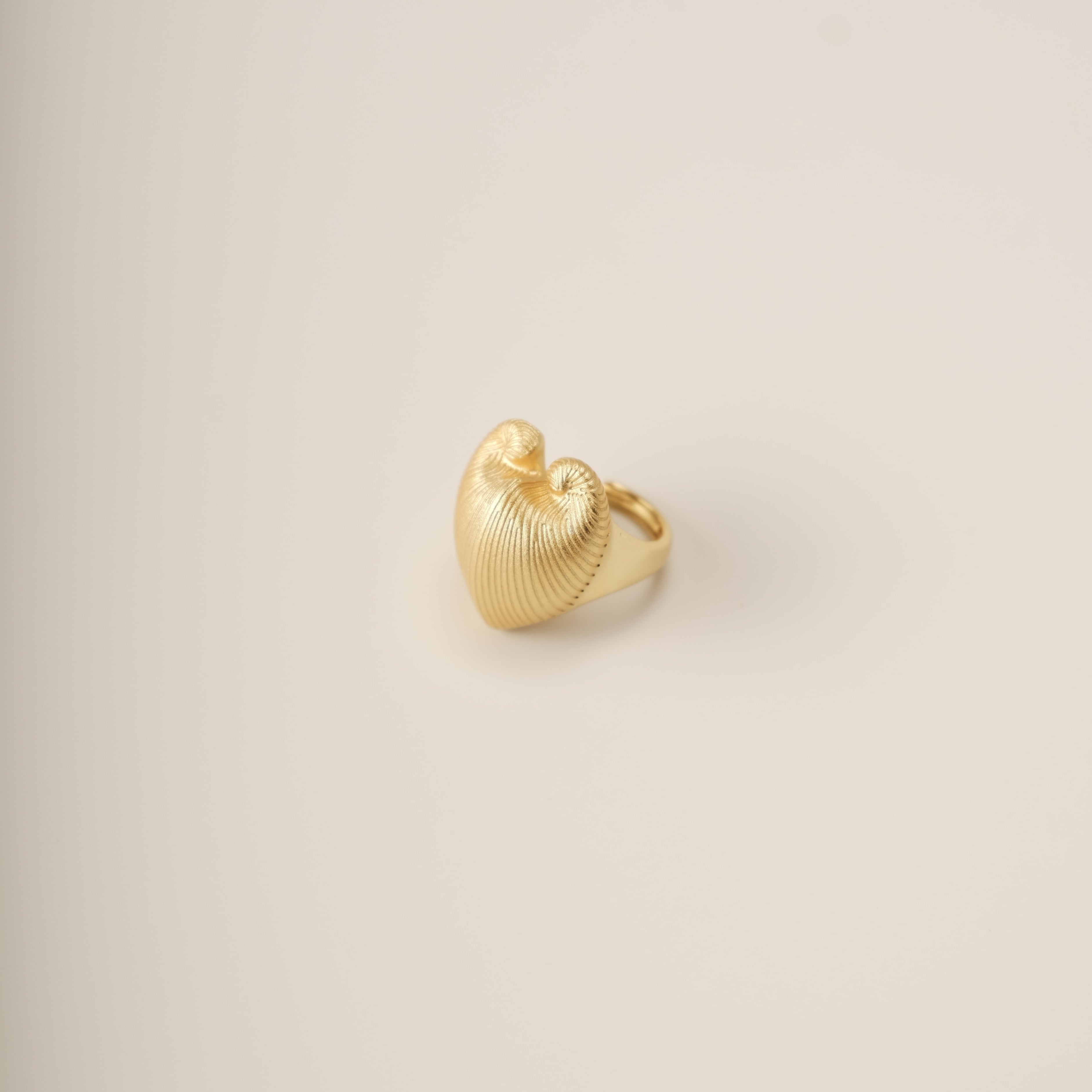 A sculptural ode to nature’s duality, the Meiocardia Vulgaris Heart Ring transforms the organic beauty of a rare marine shell into a bold, wearable statement. Crafted for those who seek depth in simplicity, this ring marries raw texture with refined elegance, embodying the balance of strength and sensitivity.
Design & Craftsmanship:
Dual-Texture Band: The ring’s surface transitions from rugged, shell-inspired ridges to a smooth, polished heart motif at its center—meticulously modeled from a 3D scan of the M