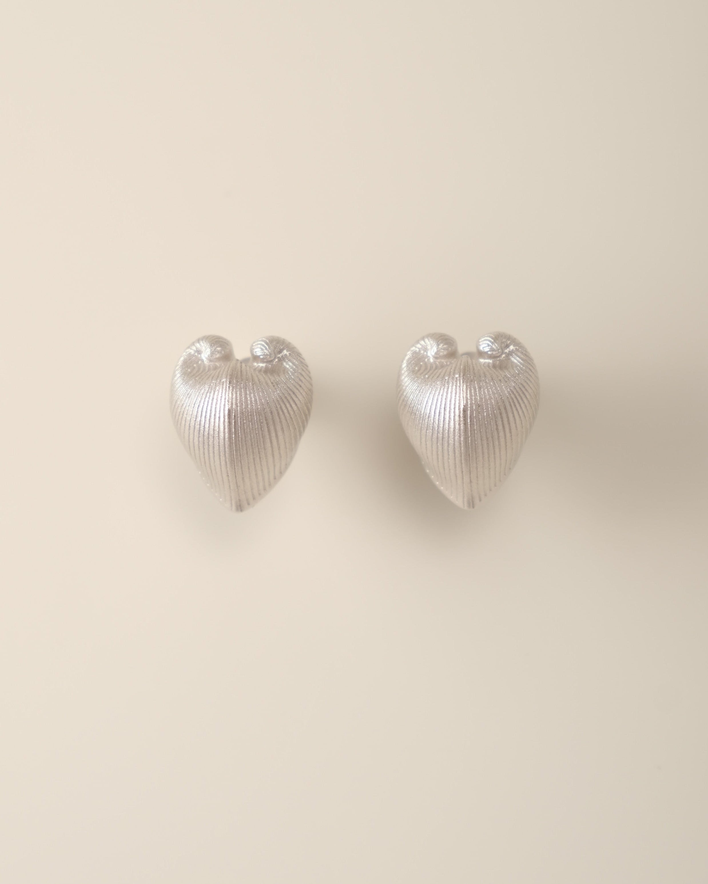 A bold yet balanced statement for the ears, the Cœur Brillant Heart Stud Earrings redefine minimalist elegance with their striking duality. Designed to celebrate contrasts, these earrings blend organic inspiration with celestial precision, offering a wearable metaphor for embracing life’s multifaceted beauty.
Design & Craftsmanship:
Dual-Texture Heart Design: Each 15.6*18.8mm earring features the Meiocardia vulgaris heart motif, cast in S925 silver and plated in your choice of 18k gold or white gold. The de