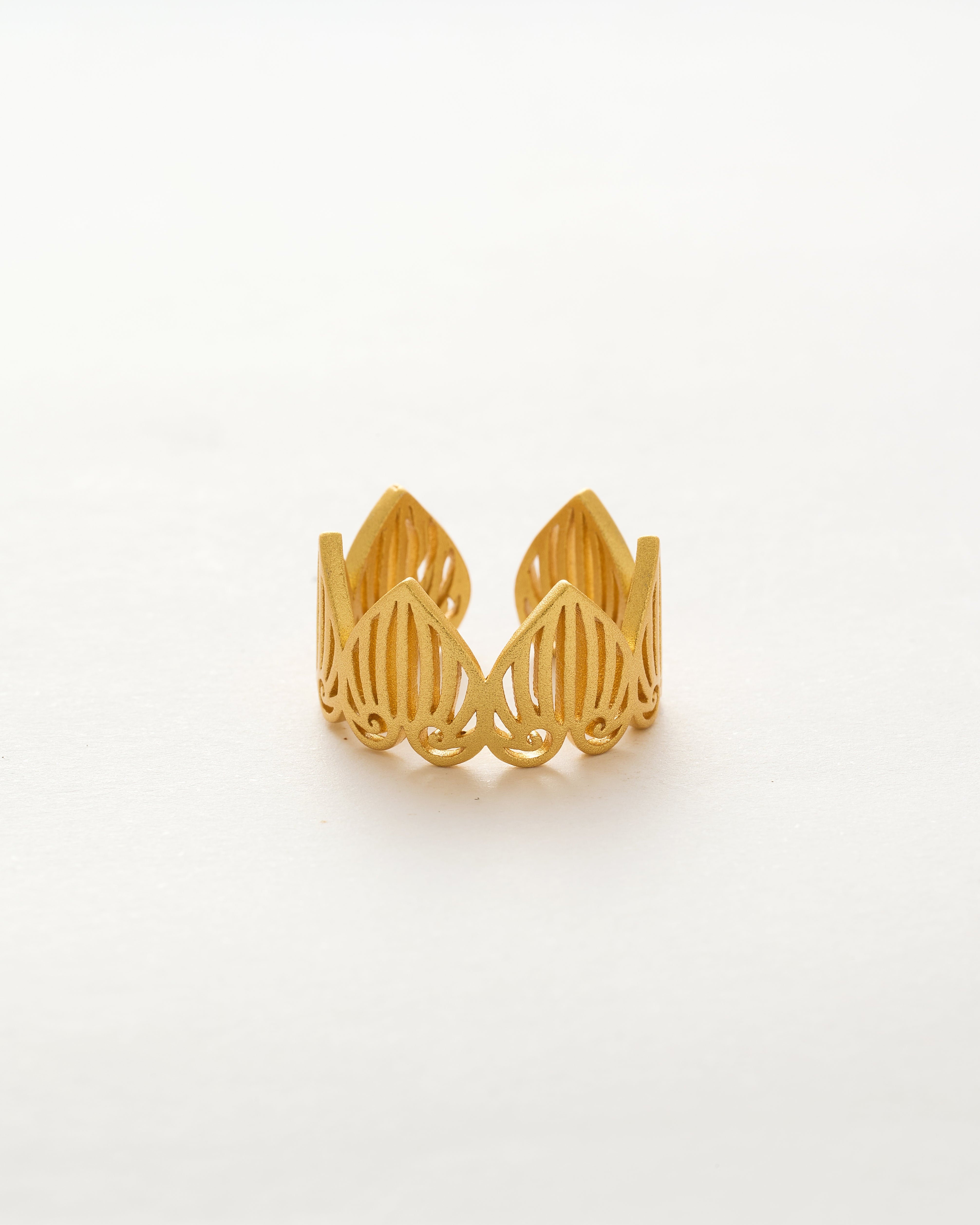 Gold wire-crafted ring on a white background