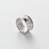 Silver ring with engraved designs on a white background