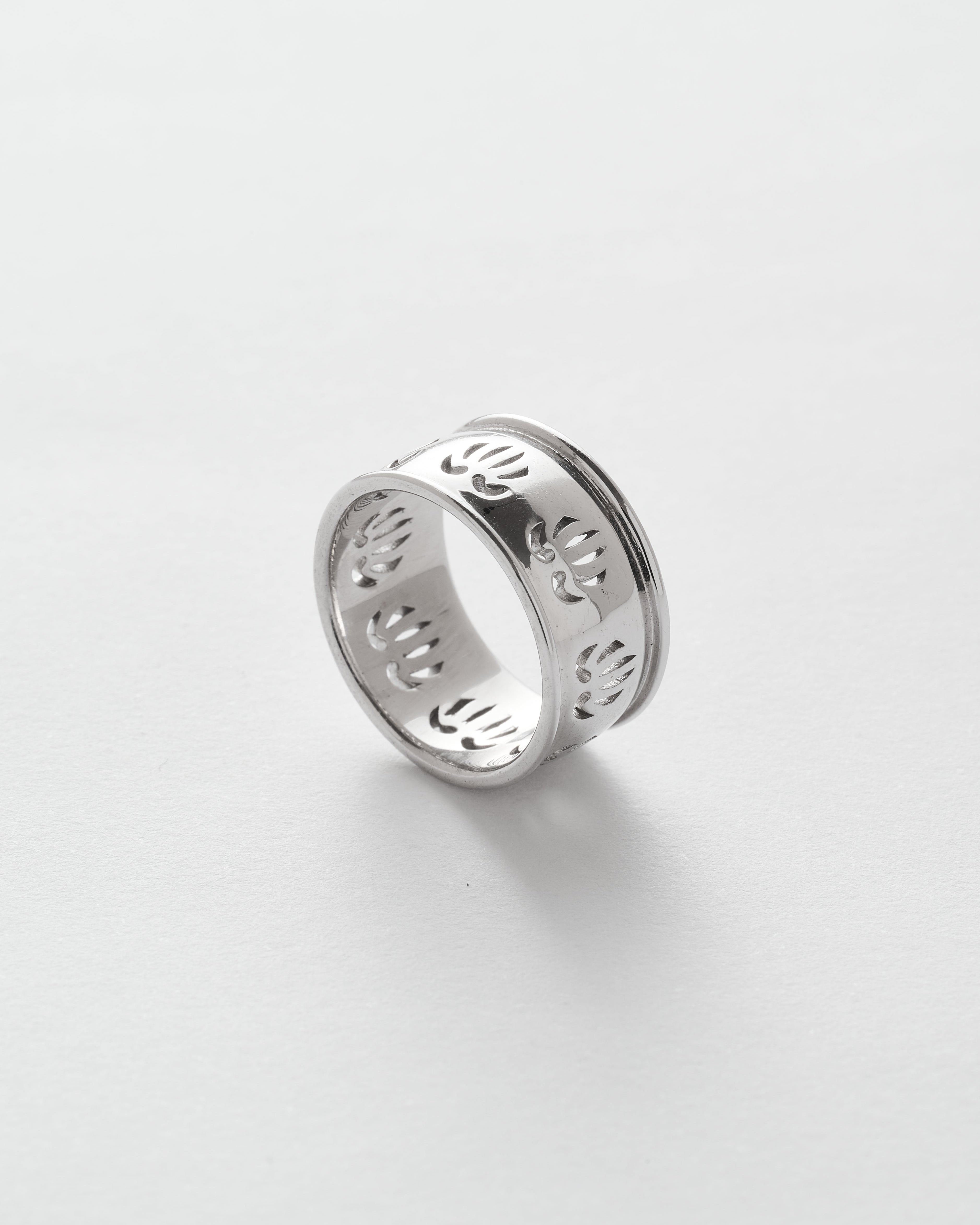 Silver ring with engraved designs on a white background