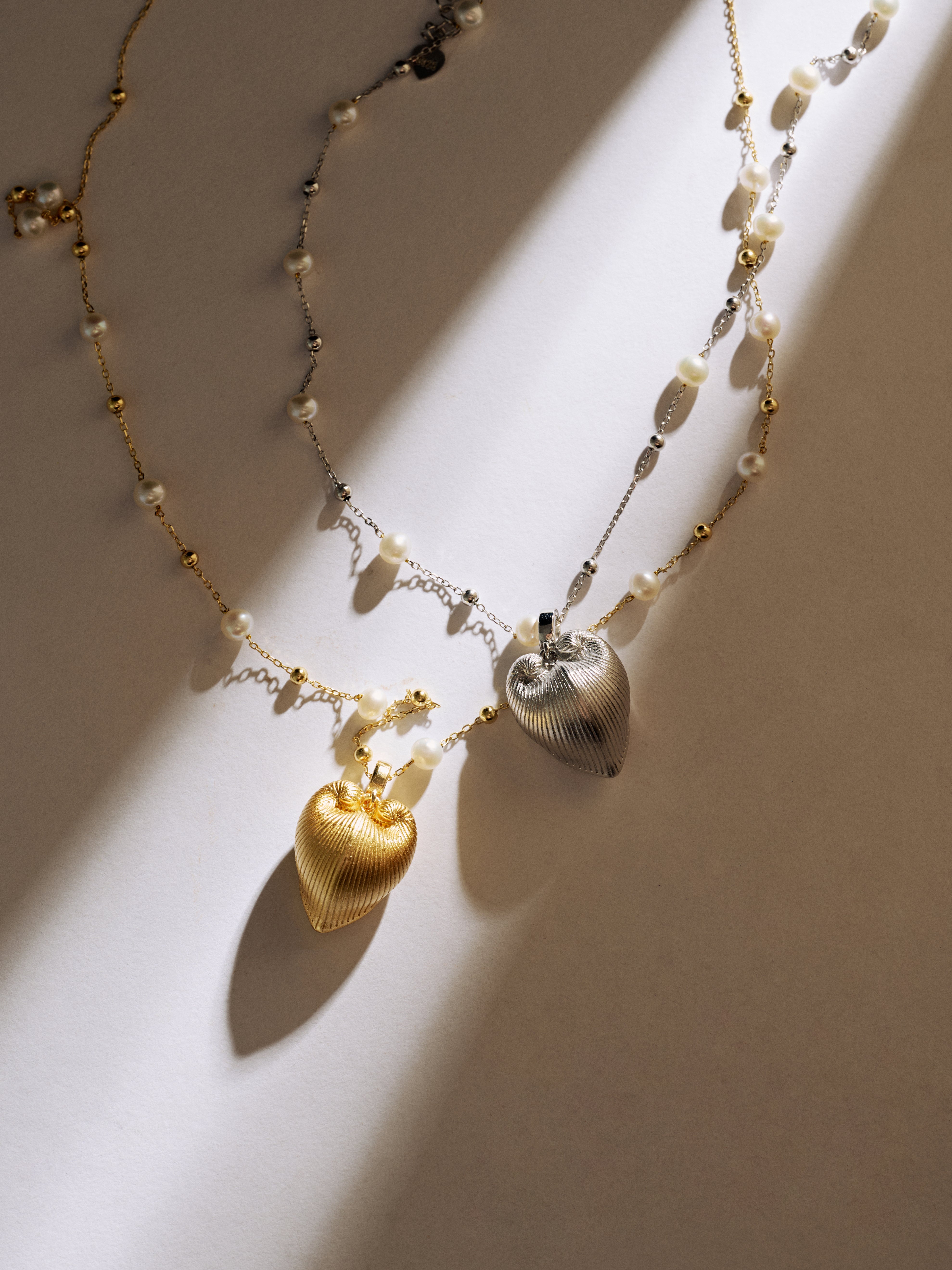 Necklace with heart-shaped pendants on a neutral background