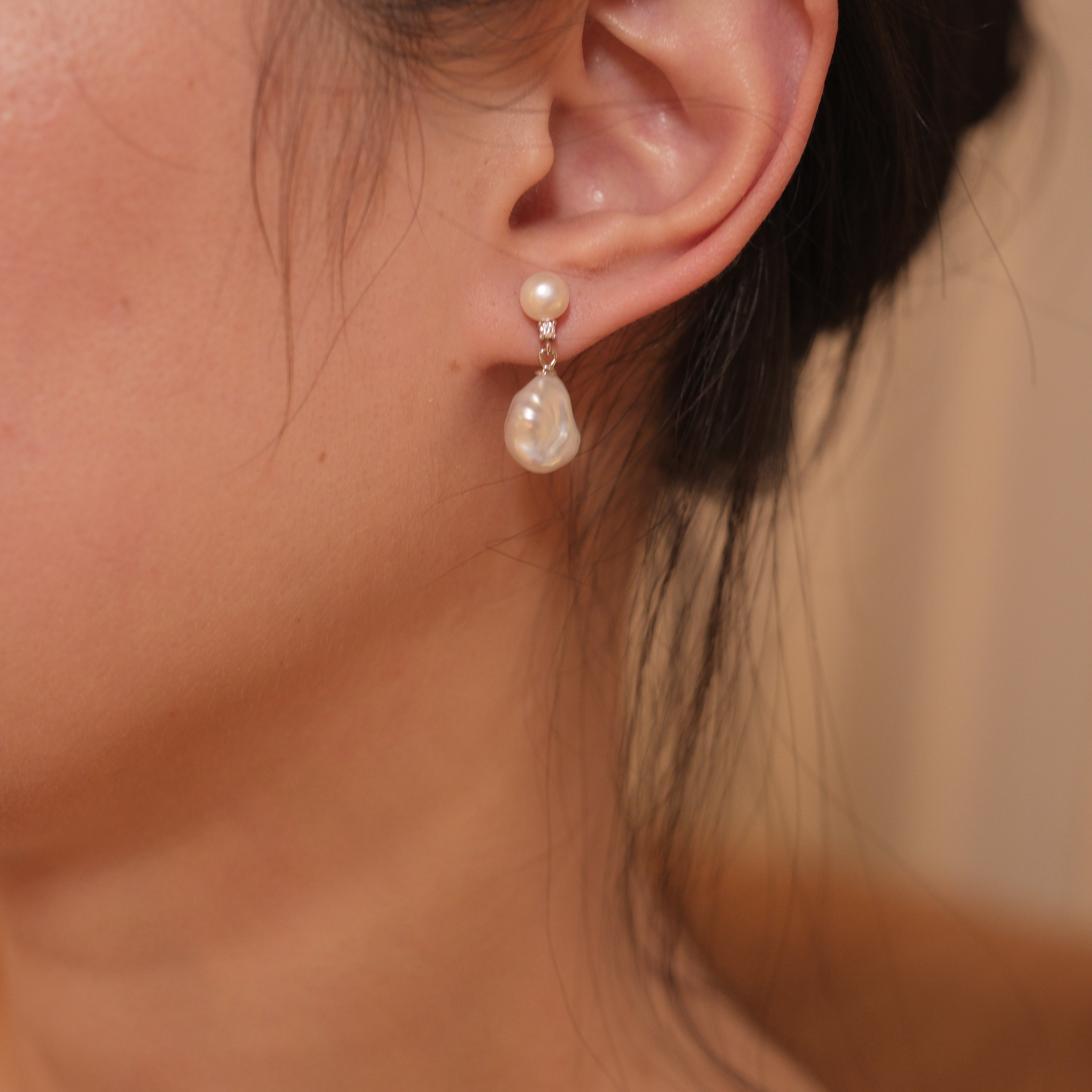 These earrings feature a detachable design that allows you to wear the round pearl with zircon accents for a minimalist look, or add the Keshi pearl for a more dramatic effect. The unique combination of differently shaped pearls with sterling silver and zircon detailing creates a stunning visual contrast, while the versatility of the design makes these earrings a must-have addition to any jewelry collection.
Materials:
- Pearls: One 10mm Keshi pearl and one 6-7mm round pearl on each earring.
- Metal: All co