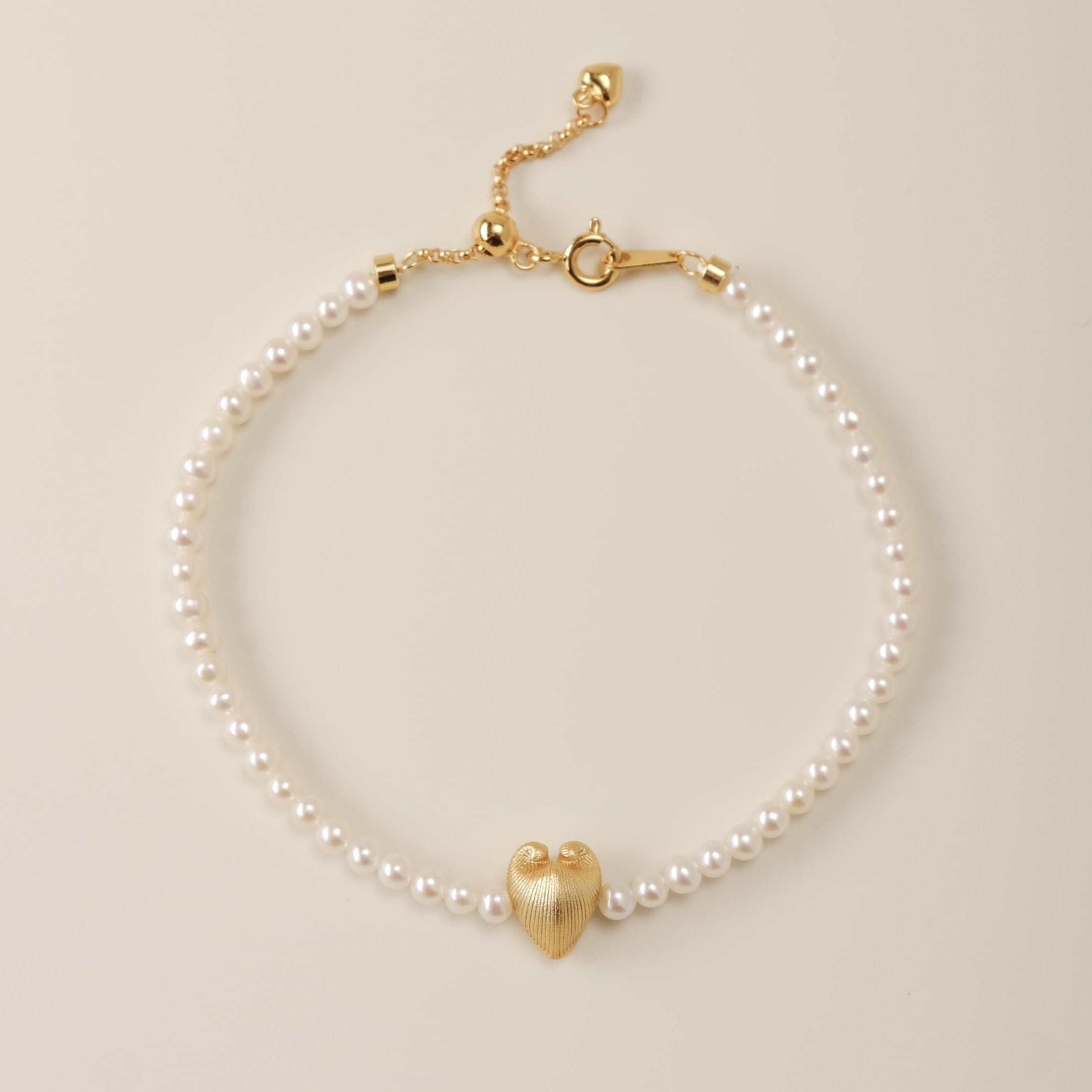 A symphony of contrasts, the Meiocardia Vulgaris Heart Bead Bracelet intertwines organic wonder with celestial elegance. Designed for those who wear their strength softly, this piece harmonizes the rare duality of nature’s hidden heart with the timeless glow of pearls.
Design & Craftsmanship:
- Dual-Perspective Heart Bead: At its center lies the 8.0*9.8mm Meiocardia vulgaris charm, 3D-modeled from a real shell scan. One angle reveals rugged, horn-like textures; the other, a smooth, luminous heart—symbolizin