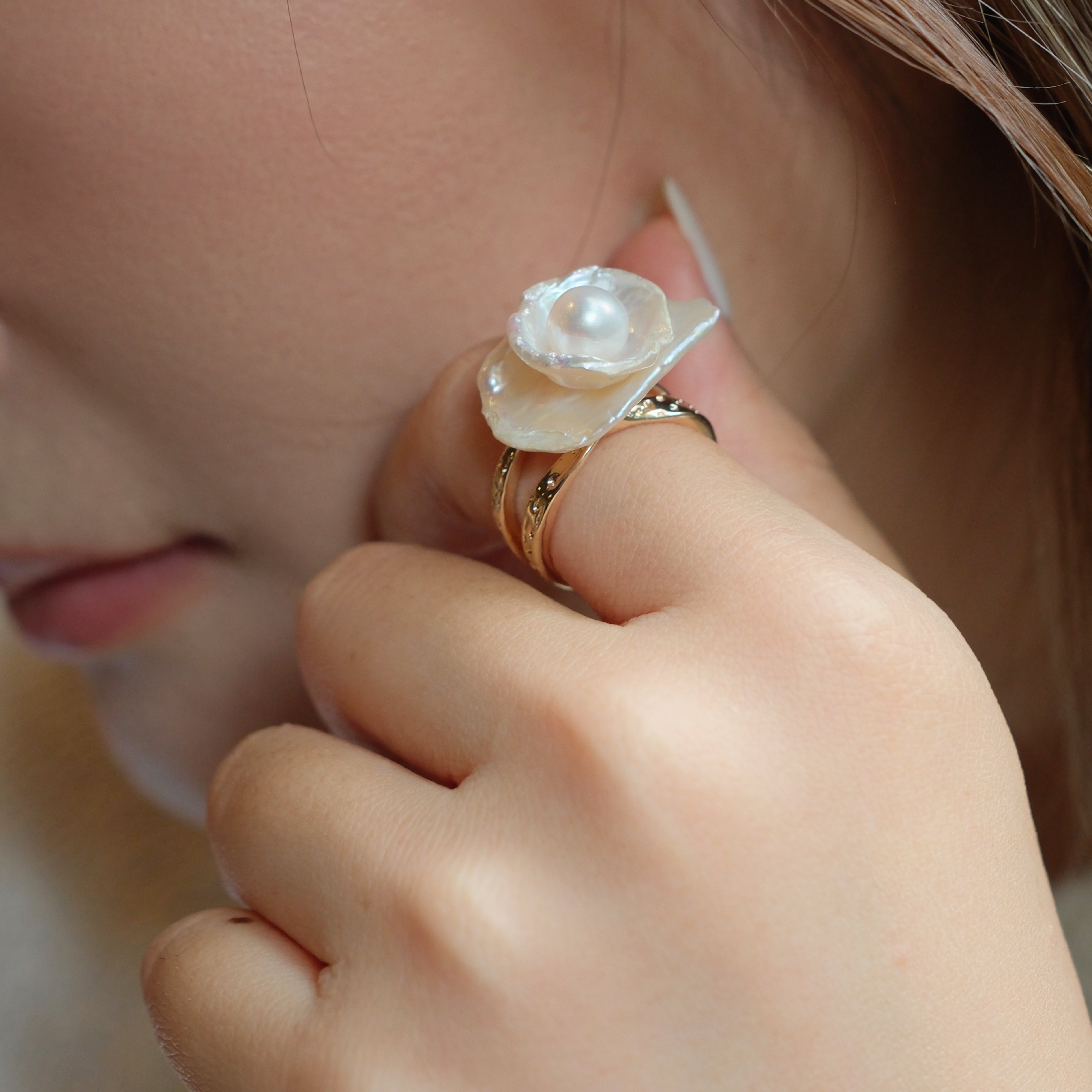 This exquisite floral ring is crafted from rare Keshi petal pearls and topped with a lustrous round freshwater pearl at its center. The natural petal pearls beautifully mimic the delicate petals of a rose, creating a unique and captivating design. The Keshi pearls, known for their irregular shape and stunning luster, make this ring a one-of-a-kind piece that’s perfect for any occasion.Ring is made using high-quality Keshi petal pearls and a freshwater pearl, set on an 18k gold-filled adjustable band