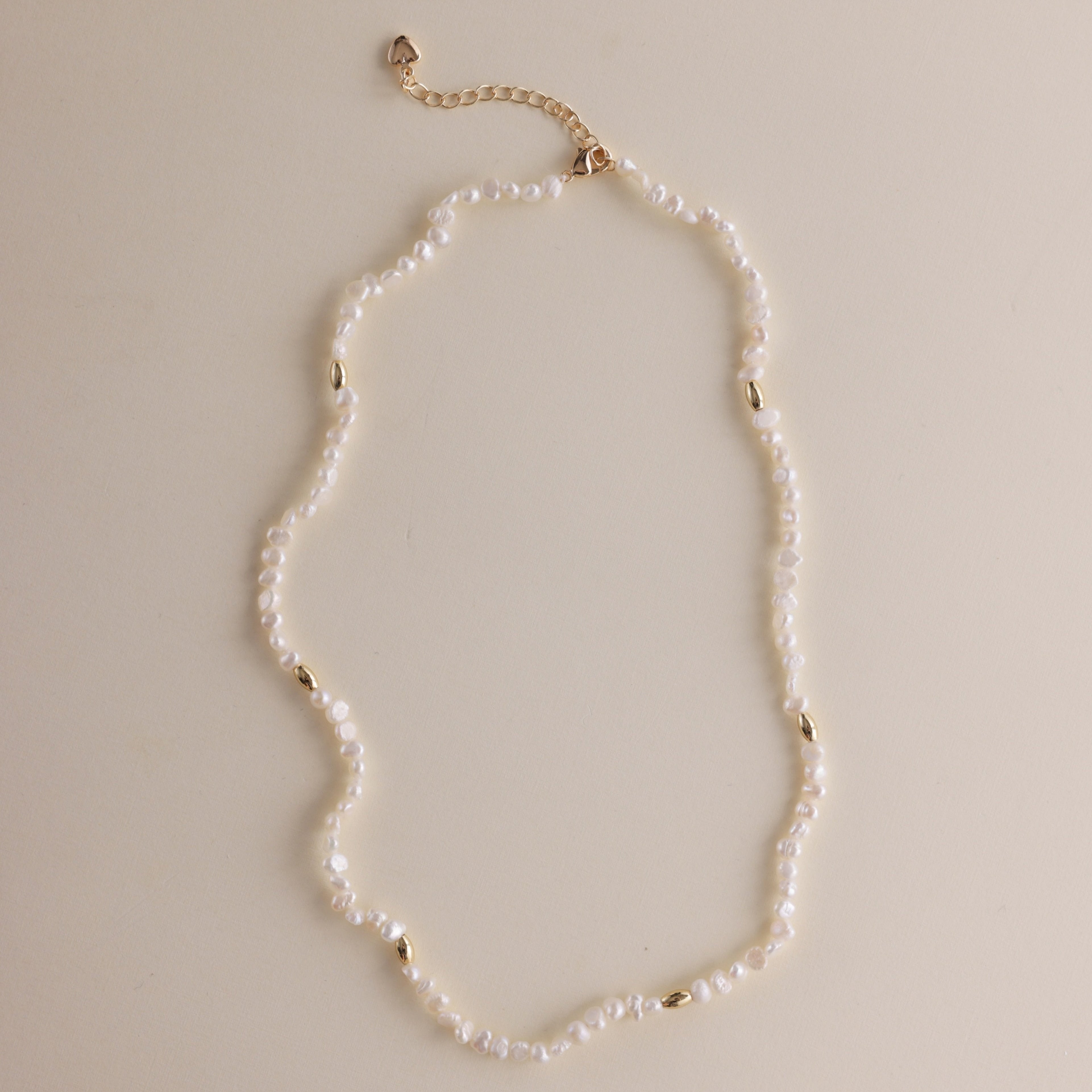 Gold and pearls—an unbeatable combination that always exudes style. This delicate pearl necklace is part of a matching set with a pearl bracelet, designed to add a chic finishing touch to your look. You can also layer it with our baroque pearl necklace for a more luxurious and bold style. Check out the listing photos for styling ideas!
- Necklace Length: 
- Extension Chain: 

Styling Tips:
This necklace is perfect for layering, whether with its matching bracelet or other pearl pieces in our collection. Pair