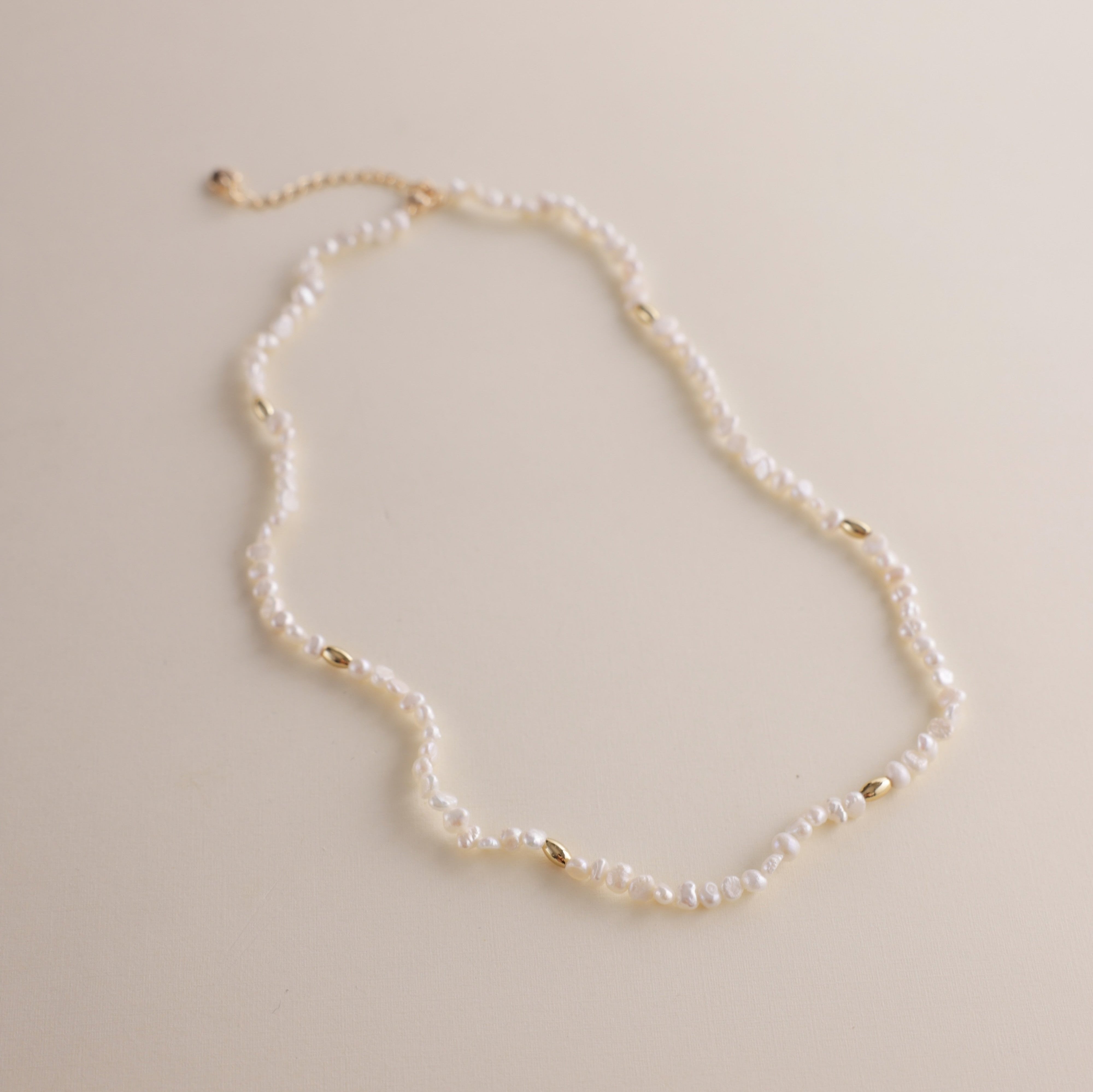 Gold and pearls—an unbeatable combination that always exudes style. This delicate pearl necklace is part of a matching set with a pearl bracelet, designed to add a chic finishing touch to your look. You can also layer it with our baroque pearl necklace for a more luxurious and bold style. Check out the listing photos for styling ideas!
- Necklace Length: 
- Extension Chain: 

Styling Tips:
This necklace is perfect for layering, whether with its matching bracelet or other pearl pieces in our collection. Pair